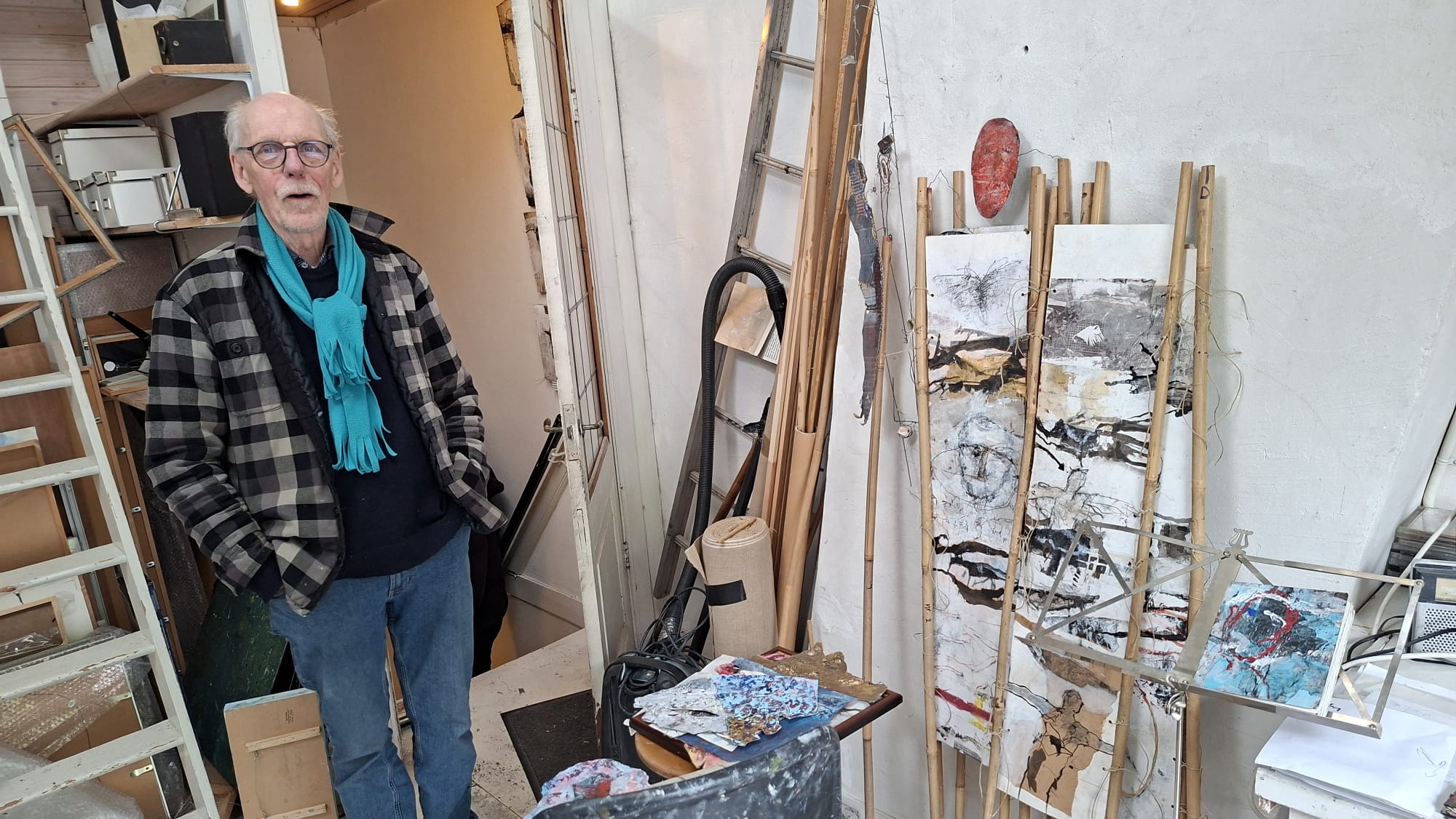 Ton Vroman in zijn atelier, omringd door werken en materialen